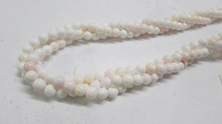 A three strand angel coral necklace in tones of pink/white.