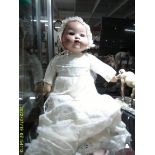 An early Chad Valley baby doll with bisque head, moving eyes and voice box.