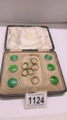 A cased set of 6 Mappin & Webb George V silver and green enamel buttons.