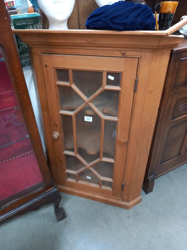 A wooden/glass corner cabinet