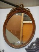 An ormolu decorated oval wall mirror. 44 x 63 cm.