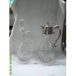 A cut glass claret jug with silver plate top (top loose) and another cut glass claret jug.