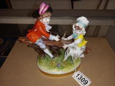 A Continental porcelain figure group of a boy and girl on a seesaw. A/F