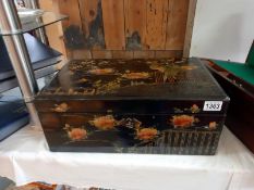 A Victorian lacquered writing box inlaid with mother of pearl.