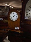 A small mahogany inlaid mantel clock.