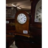 A small mahogany inlaid mantel clock.