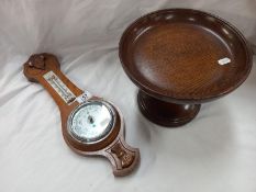 A 1930's oak aneroid barometer with silver dial