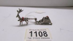 A small silver reindeer with sleigh.
