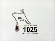 A sapphire pendant on a 9ct white metal chain, 3.4 grams.
