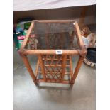 A bamboo style glass topped side table