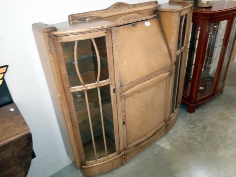 A bow front glazed writing desk with lockable doors/ key