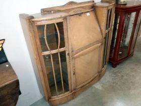A bow front glazed writing desk with lockable doors/ key