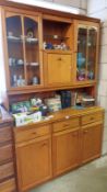 A teak style glazed wall unit