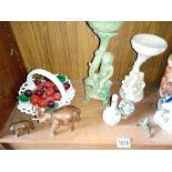 A shelf of ceramic items including a brass Asian baby