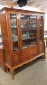 A large mid 20th century display unit with glass doors.