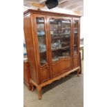 A large mid 20th century display unit with glass doors.