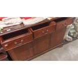 A modern dark wood, glass top, 3 draw, 2 cupboard, sideboard