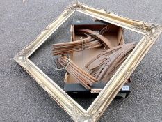 A large gilt picture frame and a box of vintage coat hangers