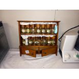 A hanging wooden spice rack with jars