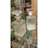2 crystal decanters with square stoppers.