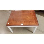 A modern dark wood coffee table with white legs