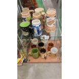 An array of pottery mugs and beer tankards. 2 shelves
