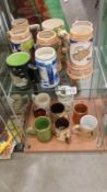 An array of pottery mugs and beer tankards. 2 shelves