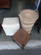 A small Lloyd loom style linen basket stool, a woven top footstool and a lidded wicker basket.