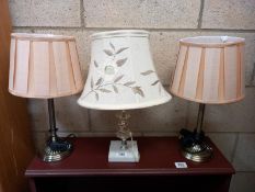 A pair of metal based table lamps and one with a metal and marble base. Collect Only.