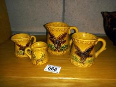 A set of 4 Eagle measure cups by Chadwick. Includes 1, 1/2, 1/4 and 1/8 measures