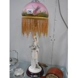 A mid 20th century figural table lamp with glass painted shade.