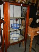 An Edwardian glazed bow front cabinet (one side glass missing). COLLECT ONLY.