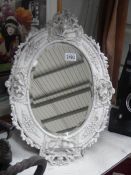A late 20th century bevel edged mirror in cherub decorated frame. COLLECT ONLY.