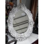 A late 20th century bevel edged mirror in cherub decorated frame. COLLECT ONLY.