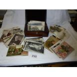 A mixed lot of old postcards and photographs in a mahogany box.