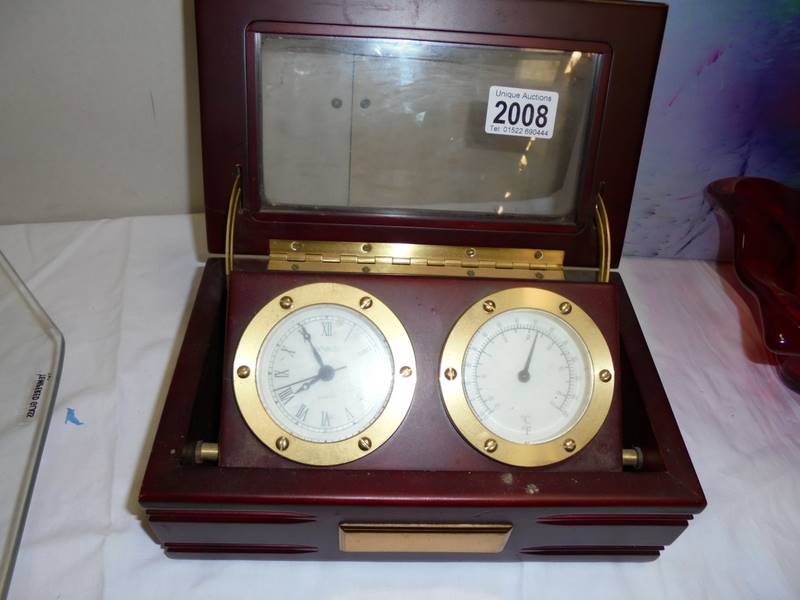 A cased brass clock and barometer.