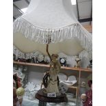 A figural table lamp with large shade.