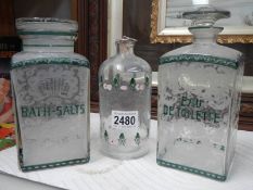 A pair of early French etched bathroom bottles and one other.