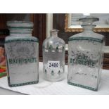 A pair of early French etched bathroom bottles and one other.