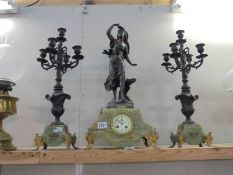 A Three piece French clock garniture - The clock with enamel dial and surmounted figure,