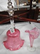 A cranberry glass bell and vase.