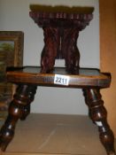 An early 20th century wooden stool and a miniature carved table.