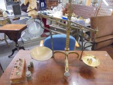 A set of brass scales and a quantity of brass weights.