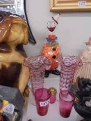 A tall glass clown, a pair of glass vases and two pieces of cranberry glass.