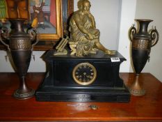 A three piece clock garniture, the clock surmounted bronze figure with 2 brass urn sidepieces.