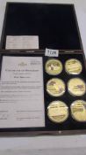 A cased set of six Rule Britannia gold plated coins with certificate.