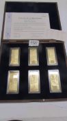 A cased set of six gold plated pound ingots with certificates.