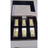 A cased set of six gold plated pound ingots with certificates.