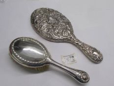 A silver backed hand mirror and a silver backed hair brush.