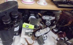 A collection of camera's, photographic accessories and binoculars.